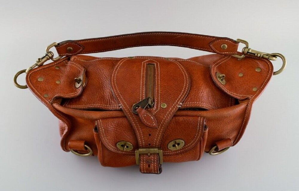 Retro Maulbeer Handtasche aus hochwertigem Kernleder mit Messingverschlüssen und Schnallen. 1980er Jahre